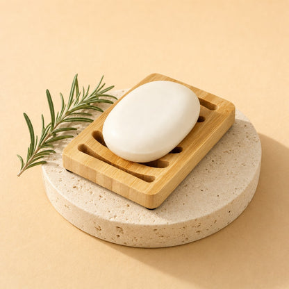 Bamboo soap dish with a bar of soap on a stone pedestal