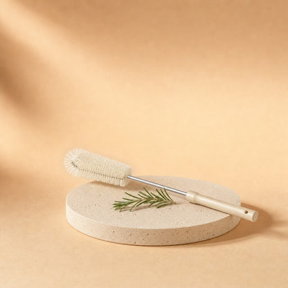 Long-handle bottle brush with wooden handle on a stone pedestal