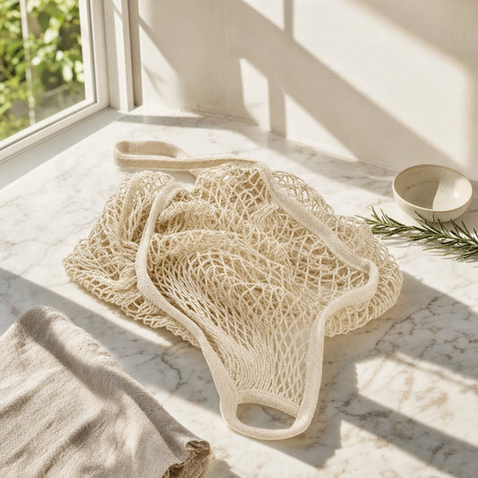 Natural cotton mesh market bag on a sunlit marble counter