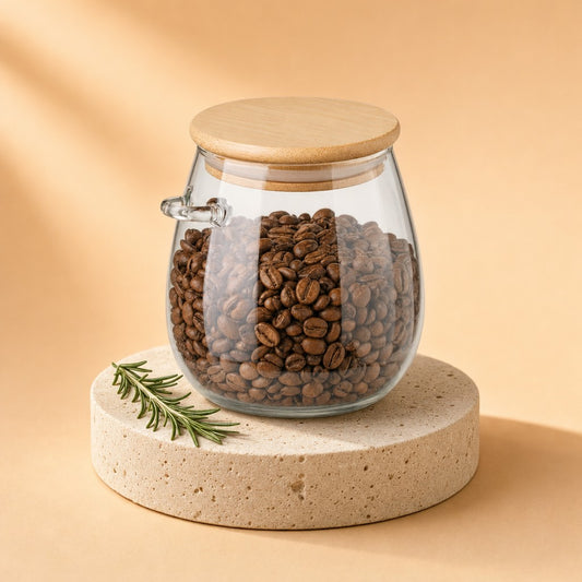 Glass storage jar with bamboo lid filled with coffee beans on a stone pedestal