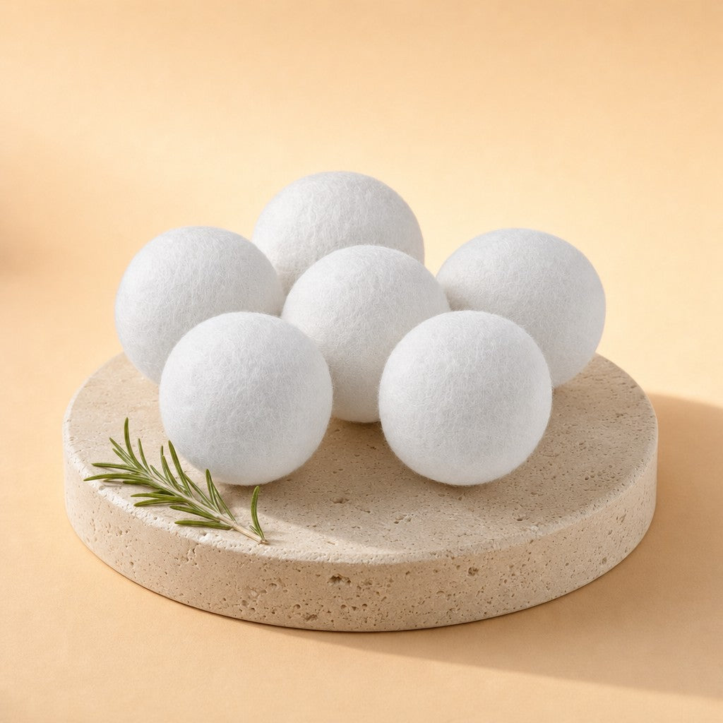 Six white wool dryer balls on a stone pedestal